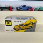 BMW M4 GT3 yellow 1:64 diecast racing car with black rear wing and alloy base – CCA