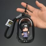 Itachi Uchiha chibi mini figure with red Sharingan-style eyes inside transparent black display case with hanging clip